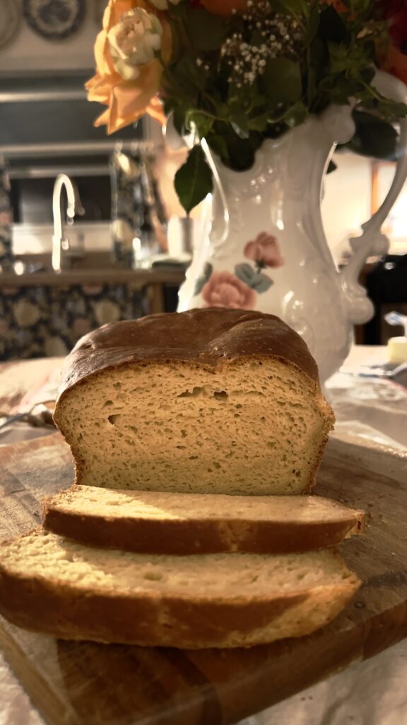 sliced loaf of gluten free. yeast bread (sandwich) on wood cutting board