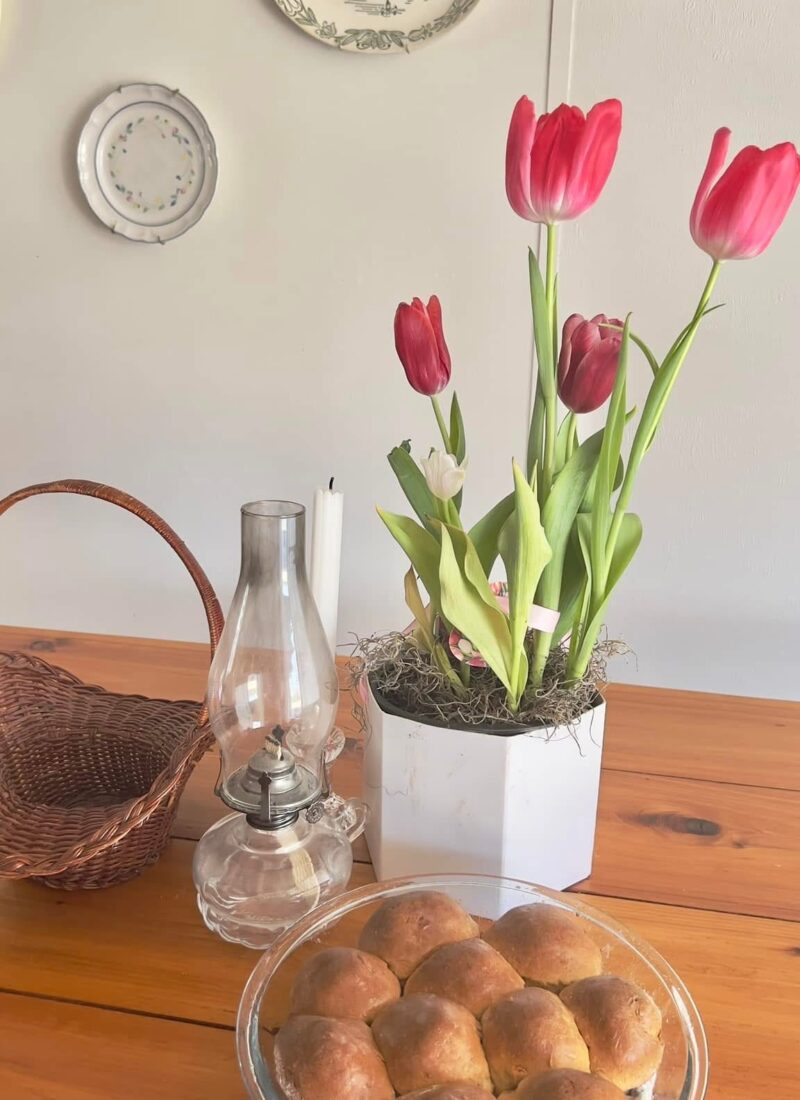 gluten free yeast rolls in glass baking dish on cedar table with pink tulips