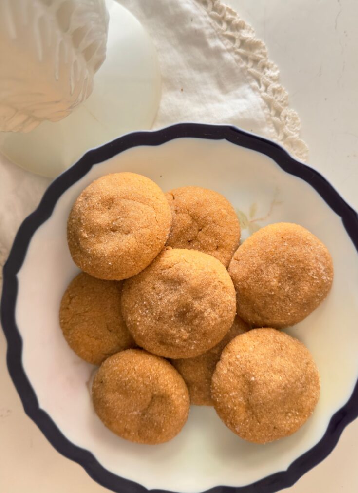 a stack of gluten free peanut butter cookies on a vintage flow blue plate and a white lace doily