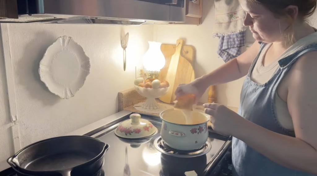 Woman pouring one packet of pectin into orange mixture