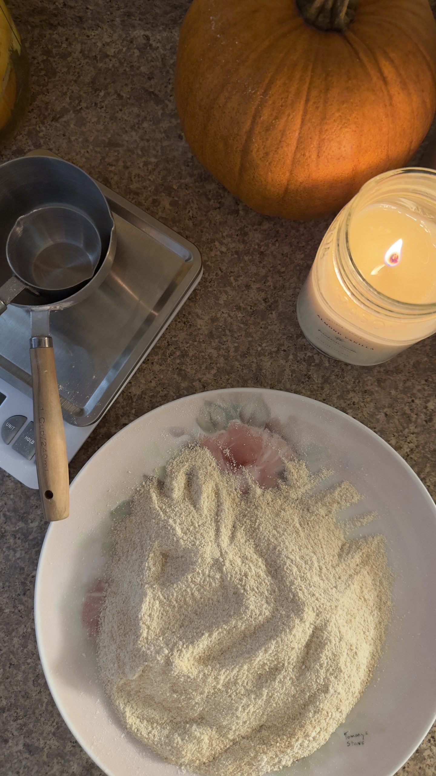 Freshly milled, whole grain flour on vintage rose plate in my country kitchen. measuring cups are stacked on a food scale.