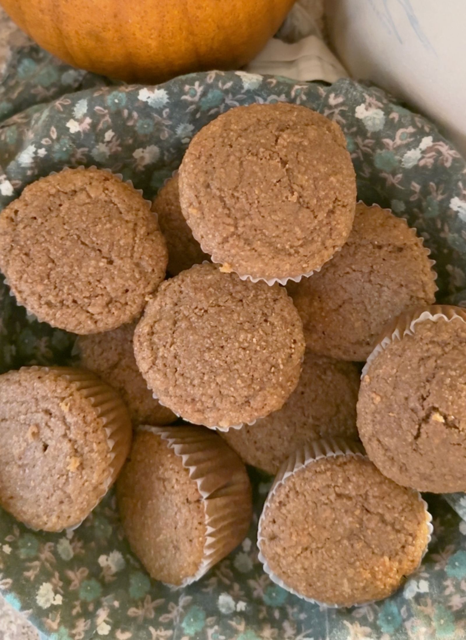 whole wheat bran muffins on a floral apron in a cozy farmhouse kitchen