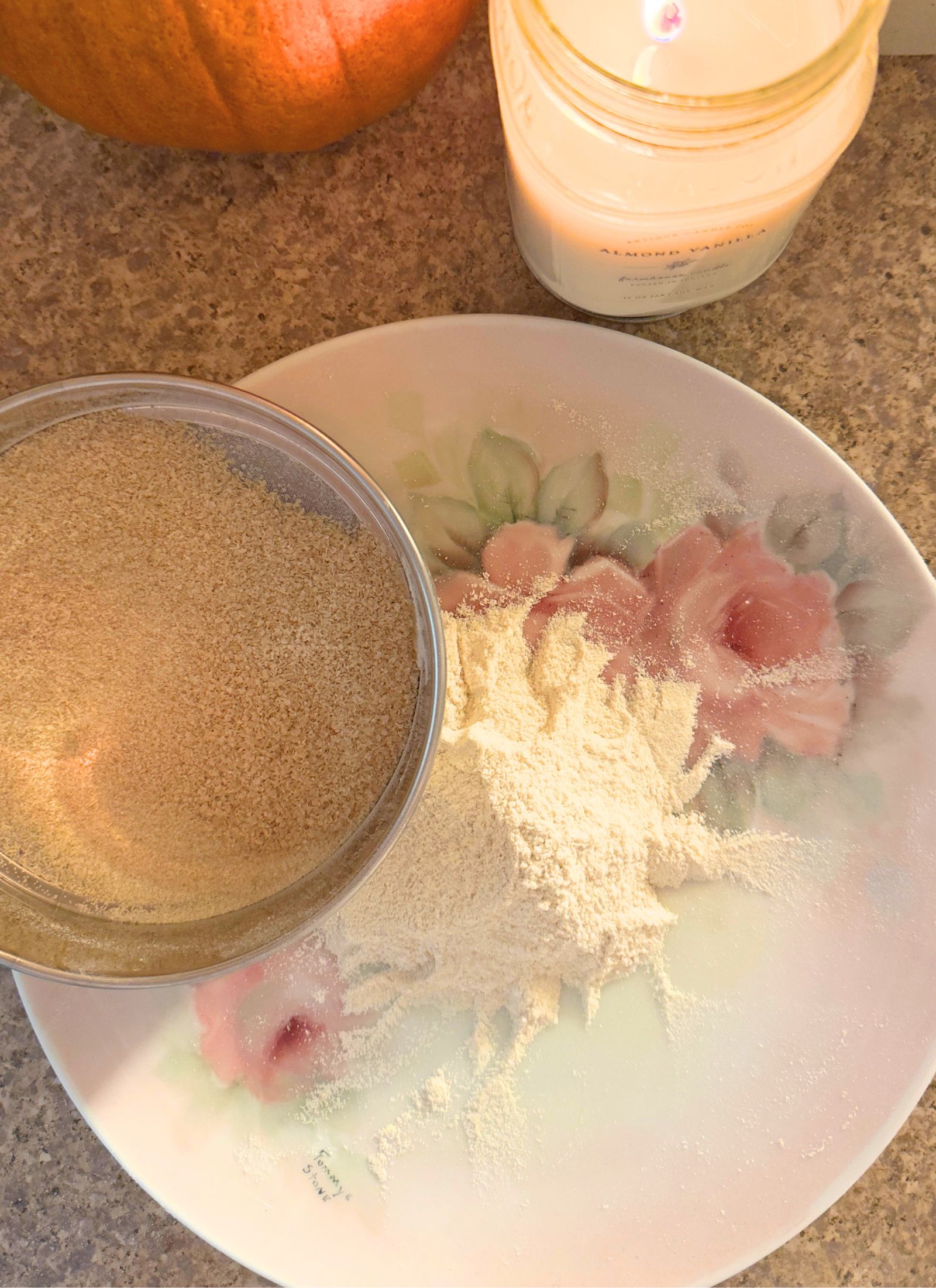 all purpose blend of freshly milled flour on a vintage rose plate. The sifted on the right while the bran remains in the sifter, also sitting on the plate. 