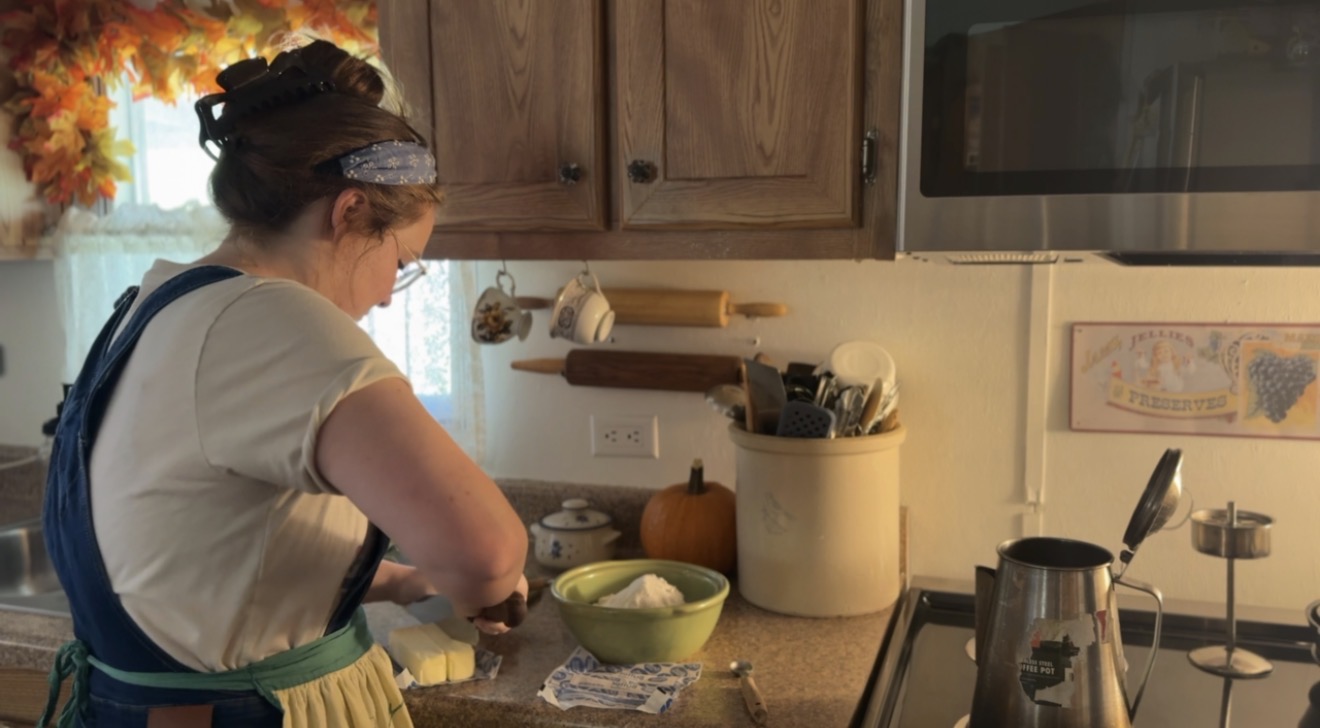 girl in farm kitchen cutting butter for deep dish pie crust